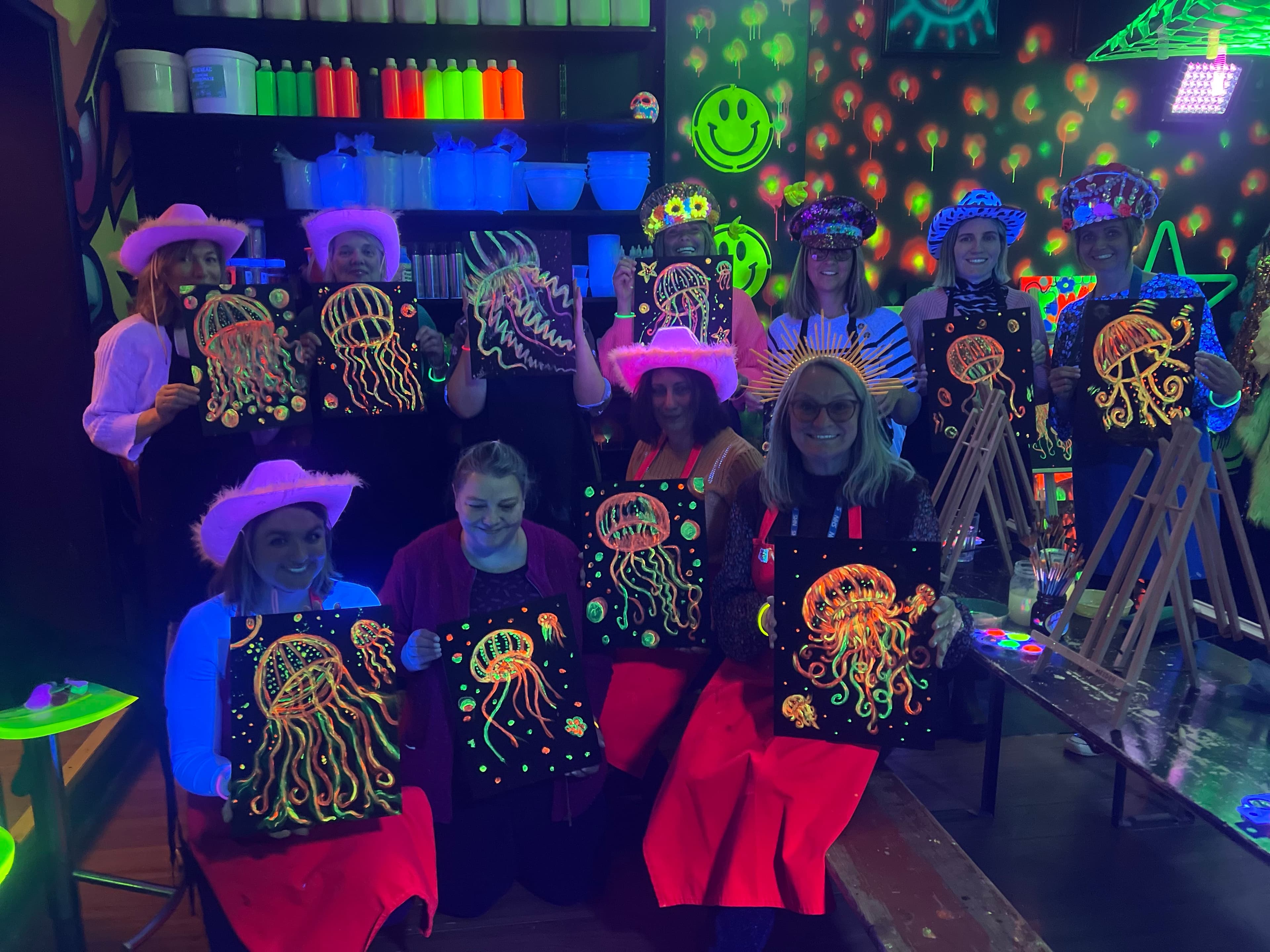 Hen party group holding neon jellyfish paintings at art-ful