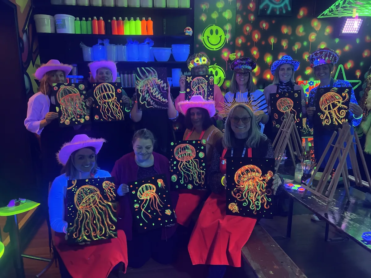 Hen party group holding neon jellyfish paintings at art-ful