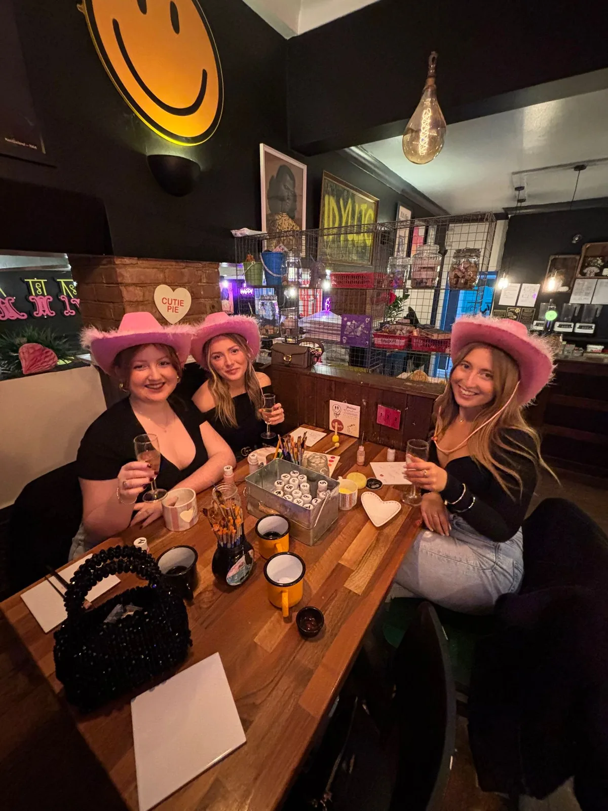 Hen party guests in pink cowboy hats with prosecco at art-ful Worthing